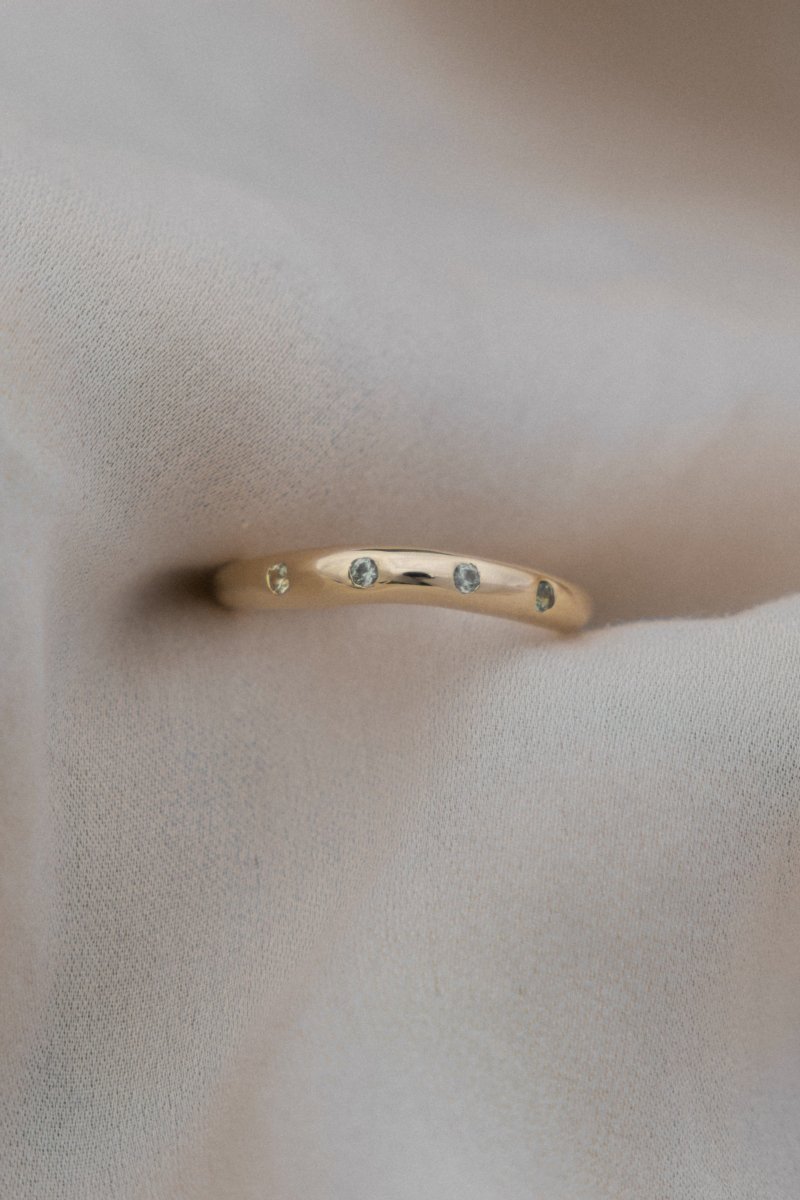 WAVY HANDCRAFTED SOLID GOLD RING FLUSH SET WITH FOUR GREEN SAPPHIRES