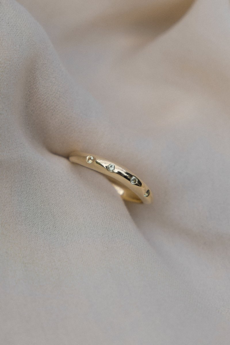 WAVY HANDCRAFTED SOLID GOLD RING FLUSH SET WITH FOUR GREEN SAPPHIRES