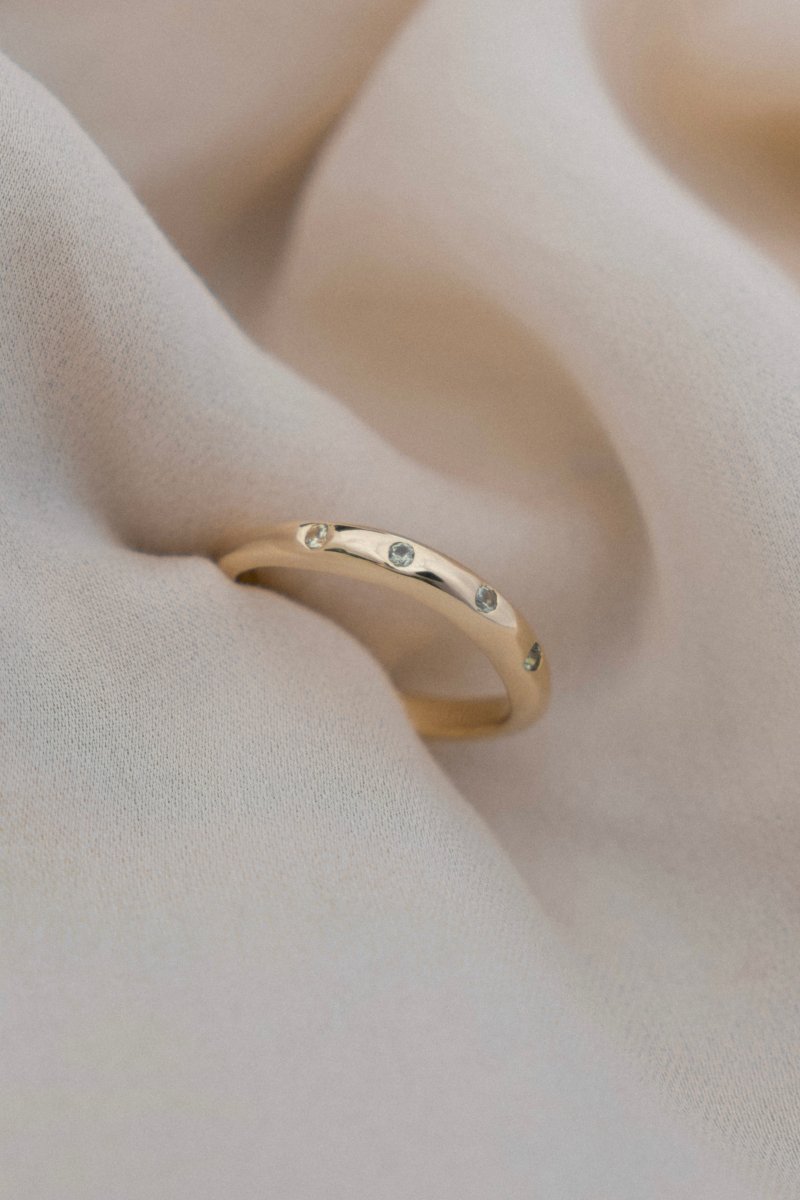 WAVY HANDCRAFTED SOLID GOLD RING FLUSH SET WITH FOUR GREEN SAPPHIRES